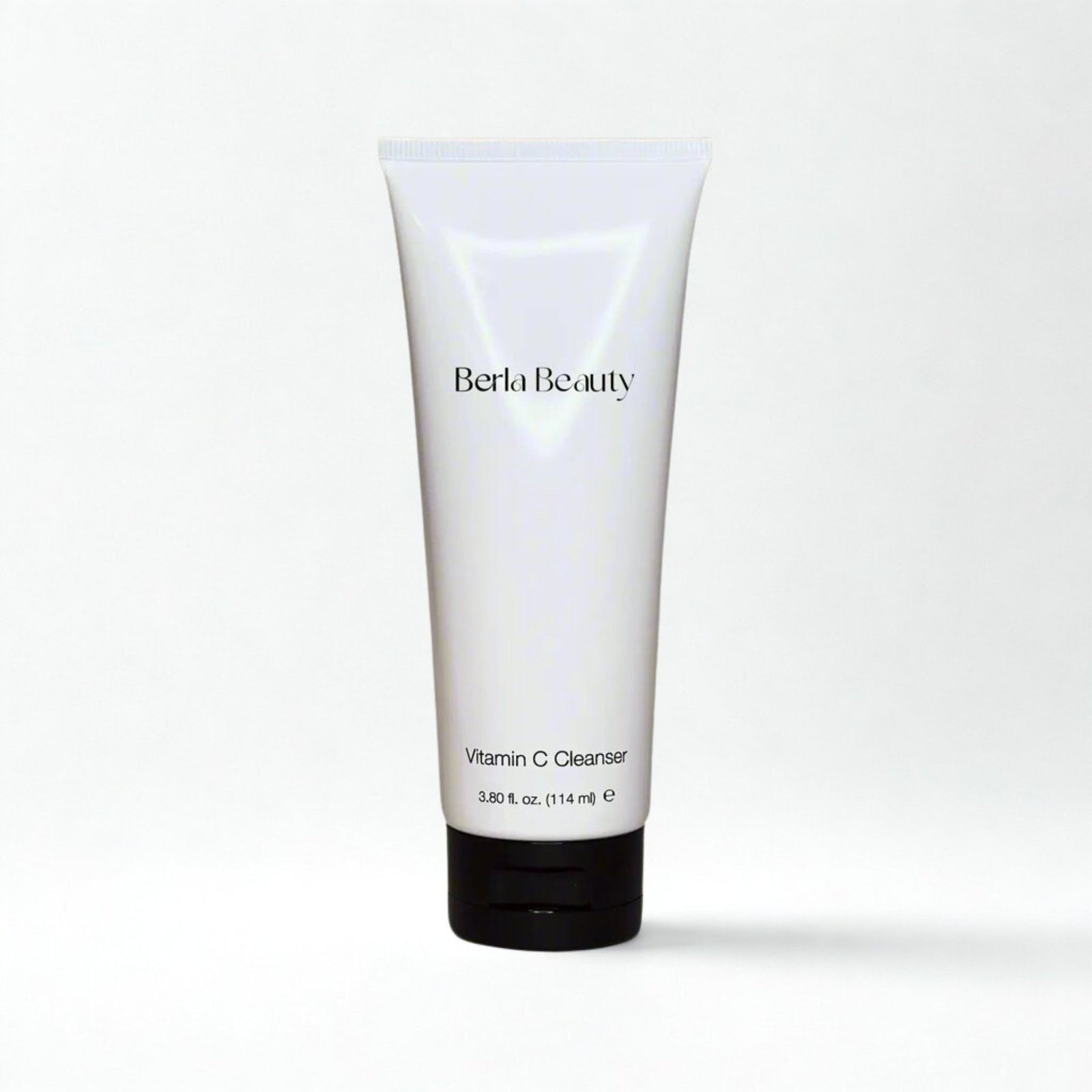 A white tube labeled "Vitamin C Cleanser" by Berla Beauty contains a formulation that brightens skin and supports collagen production. The tube features a black cap and holds 3.8 fl. oz. (114 ml) of product, set against a simple background with neutral colors.