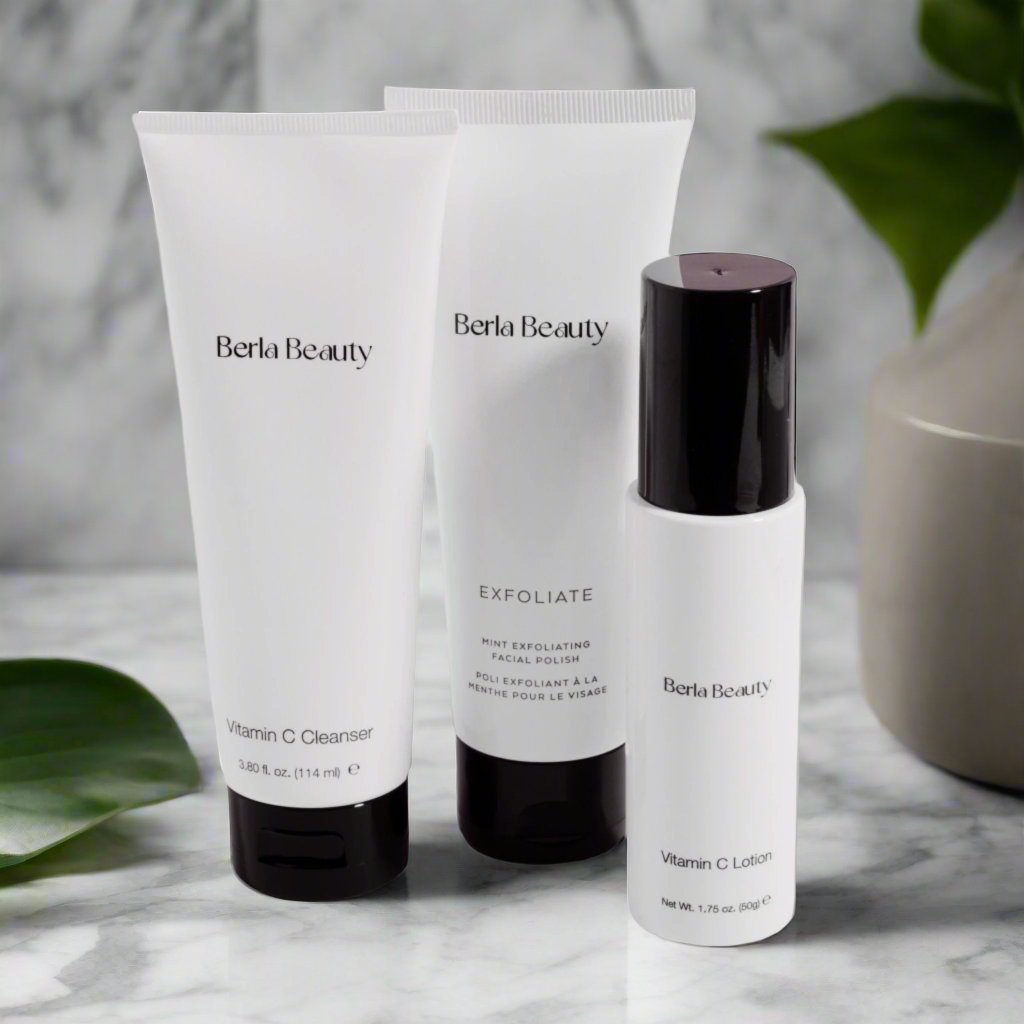 Image of Berla Beauty's Total Skincare Trio, featuring a Vitamin C Cleanser, a Mint Exfoliating Facial Polish, and a Vitamin C Lotion. The products are elegantly displayed against a light gray background.